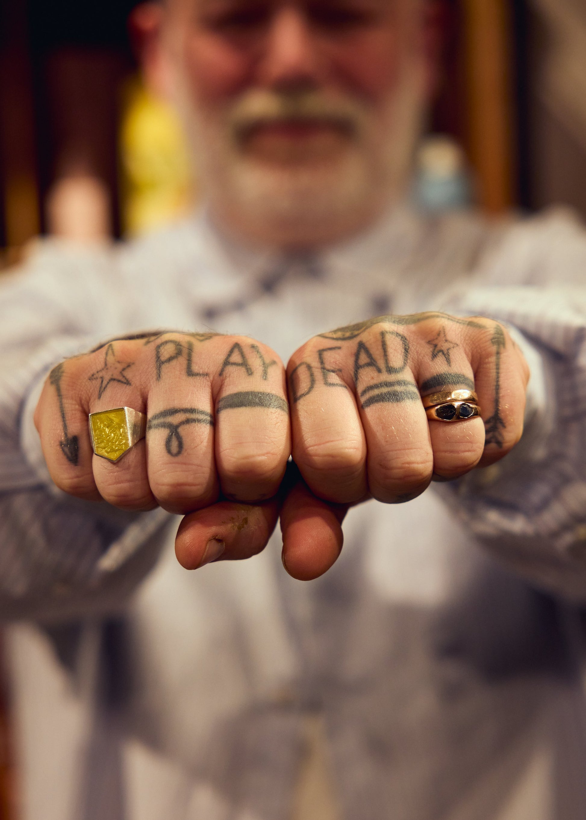 Adam Reed showing his PLAY DEAD hand tattoos in the Yellow Edition campaign