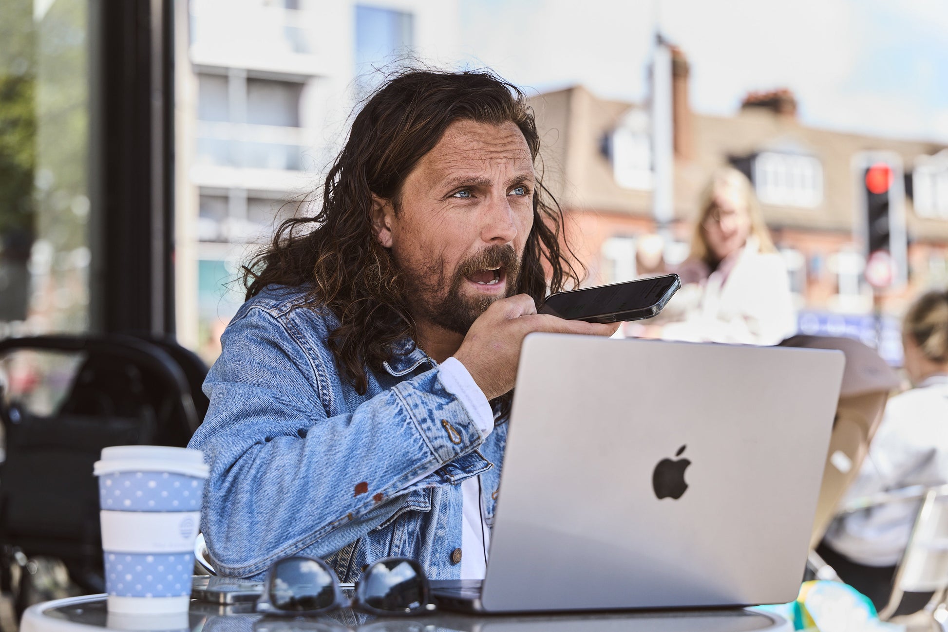 James Busby recording content beside his laptop