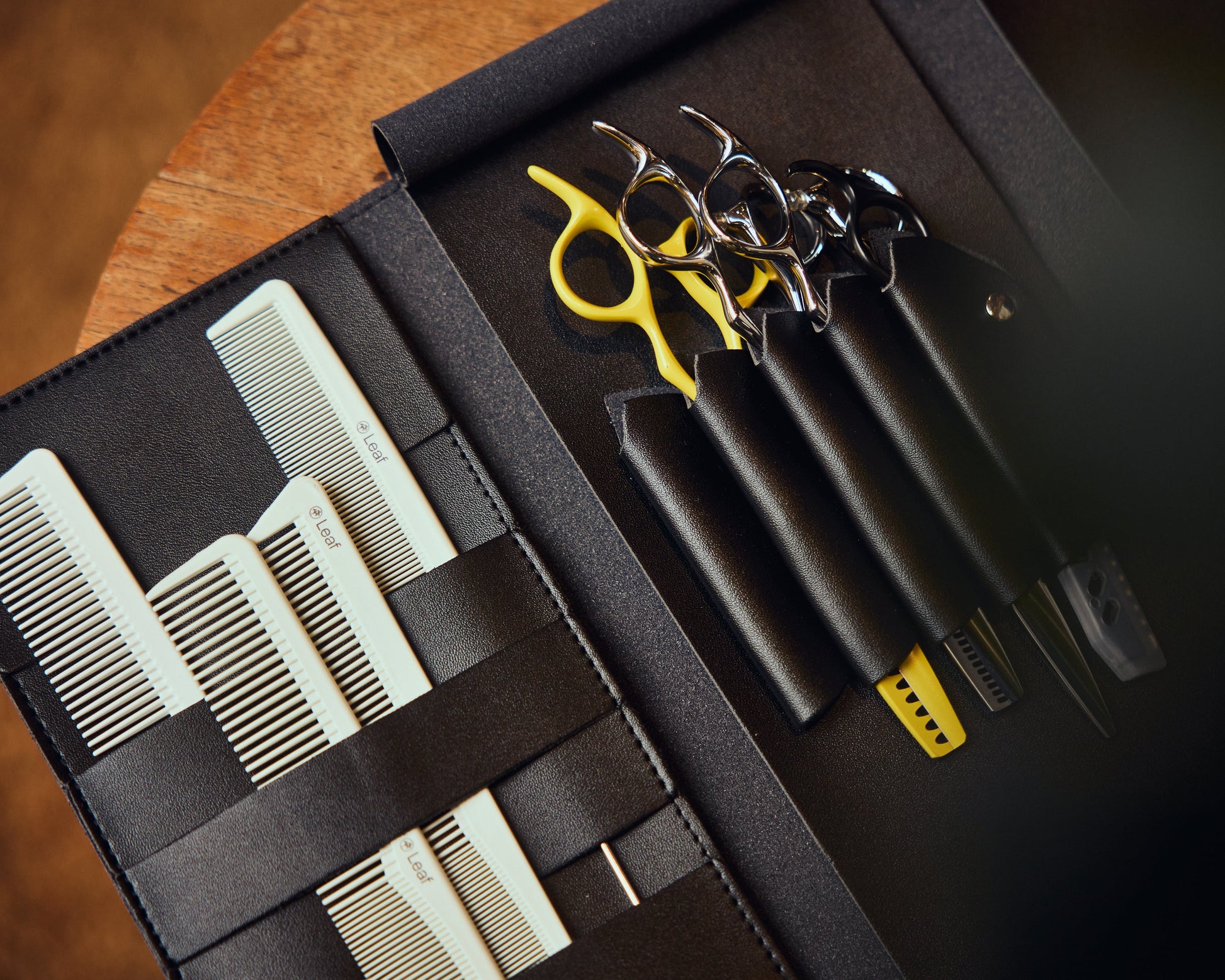 Leaf professional scissors and combs arranged in a black hairdressing kit