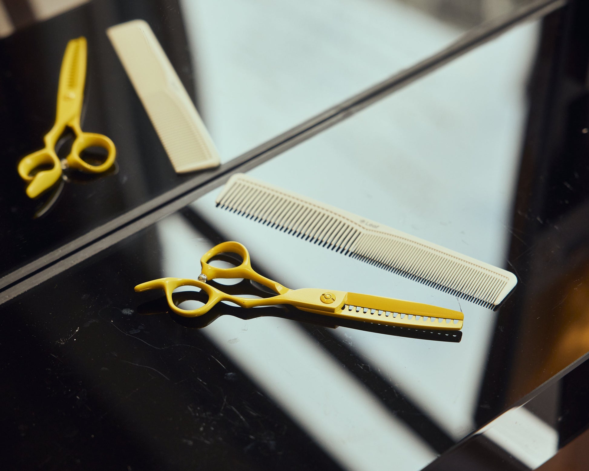 Leaf Yellow Shatter Shear displayed beside a professional cutting comb